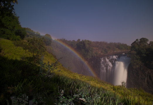 Victoria Falls,Zimbabwe-August 17, 2016: A lunar rainbow or a moonbow on the Victoria Falls observed within 2 days of full moon. Since the lunar rainbows are much fainter than the day-time ones, long-