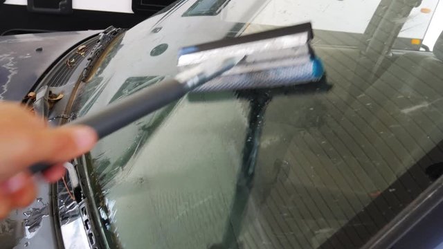 POV cleaning windshield on vehicle