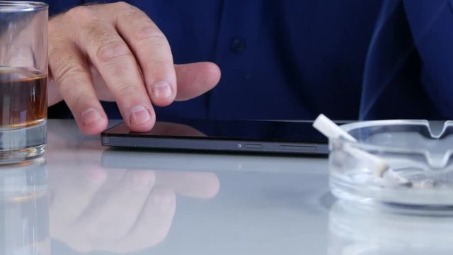 Nervous Man Smoke a Cigarette Drink Alcohol and Play with Smartphone