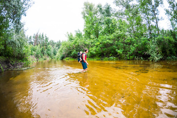 A man with a child crosses the river ford.
