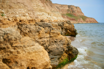 Fototapeta na wymiar beautiful seaside landscape, closeup of stone on the beach, sea coast with high hills, wild nature