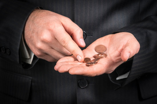 businessman counts coins in the palm