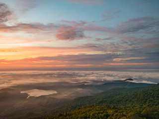 Fototapeta na wymiar Beautiful Sunrise Sky with Sea of the mist of fog and heart shaped lake in the morning on Khao Luang mountain in Ramkhamhaeng National Park,Sukhothai province Thailand
