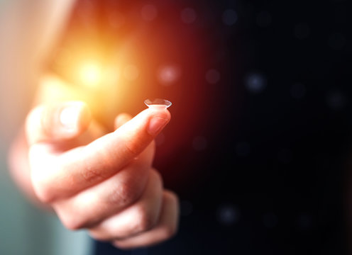 Focus on contact lens on finger of young handsome teen man young male . Close-up Of Young Man Holding Contact Lens On Finger Eyesight and eyecare concept. Ophtalmology concept versus wearing glasses