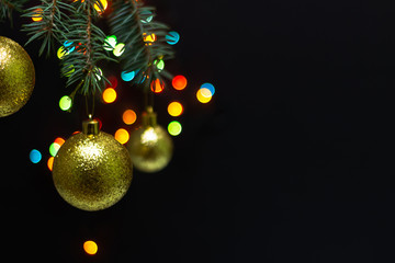 A yellow ball weighs on a Christmas tree on a blurred background with bokeh