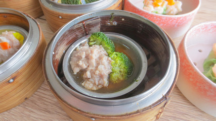 close up of set steamed dim sum dumplings in basket, chinese traditional food