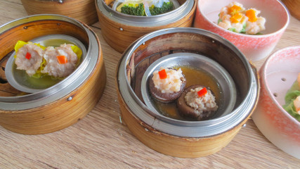 close up of set steamed dim sum dumplings in basket, chinese traditional food