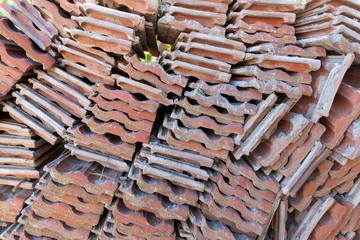 Red clay roof tile put in the stack after old tenement renovation in central Turkey, texture.