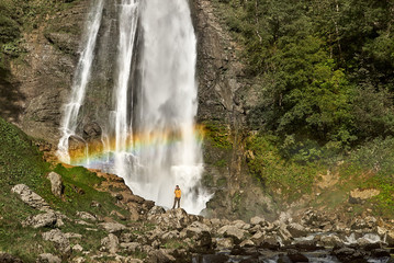 Hiker Enjoying the Scenic Waterfall with rainbow.