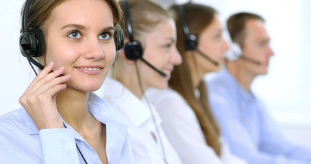 Call center operator in headset while consulting client. Telemarketing or phone sales