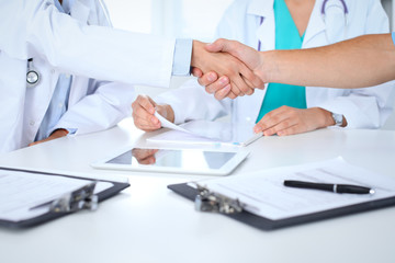 Two doctors shaking hands to each other at meeting. Teamwork and agreement in medicine