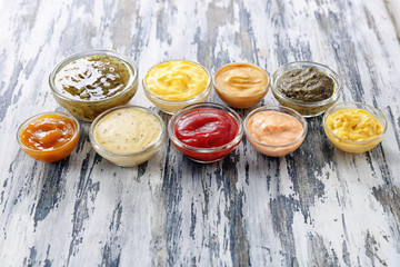 Different tasty sauces in bowls on wooden table