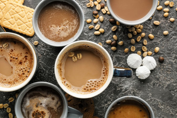 Many cups with tasty aromatic coffee and cookies on grey table, flat lay