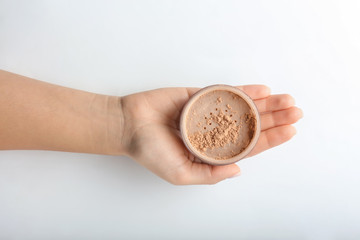 Fototapeta premium Woman holding powder on white background