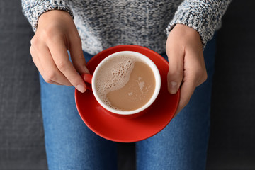 Woman holding cup of aromatic coffee, closeup