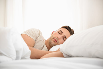 Handsome man sleeping in bed at home