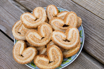 Palmier cookies in a plate on wooden table