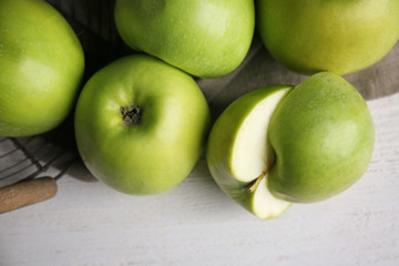 Whole and cut tasty apples on wooden table