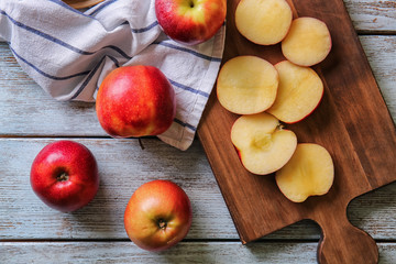 Whole and cut tasty apples on wooden table