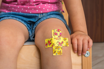 Child with adhesive bandage on knee