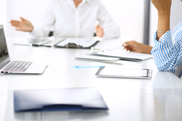 Group of business people at meeting in office, close-up. Team of two women discussing deal. Negotiation concept