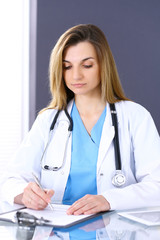 Woman doctor at work in hospital office. Portrait of female physician. Medicine and health care concept