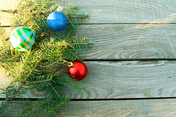 Christmas fir tree branches and Christmas decorations on wooden background. Top view, copy space