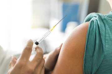 Vaccine or flu shot in injection needle. Doctor working with patient's arm. Physician or nurse giving vaccination and immunity to virus, influenza or HPV with syringe. Appointment with medical expert. - obrazy, fototapety, plakaty