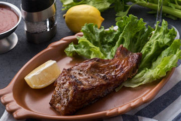Grilled sturgeon on a plate with lemon and sauce. Grilled sturgeon on a plate