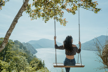 asian woman portrait on a swing with beautiful nature background