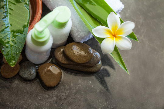 Cream tubes for treatment. Body care and spa concept with tropical flofer, stones and towel