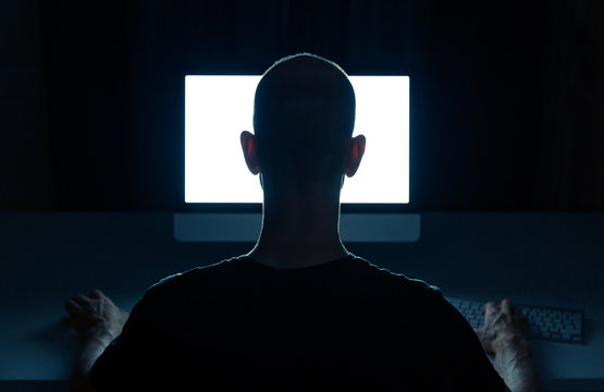 Man with criminal intentions hacking from a desktop computer.