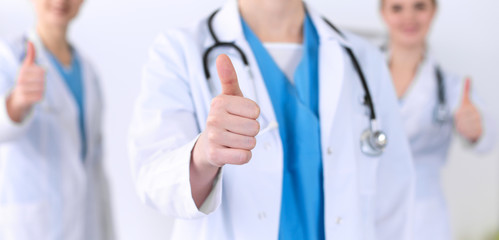 Groupe of medicine doctors show OK sign with thumb up close up. Success and high level service in health care, best treatment and customer loyalty and physical concept. Copy space for advertisement