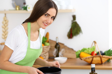 Beautiful Hispanic woman cooking soup in kitchen. Healthy meal and householding concepts