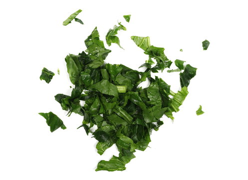 Fresh sliced, cut up spinach leaves isolated on white background, top view