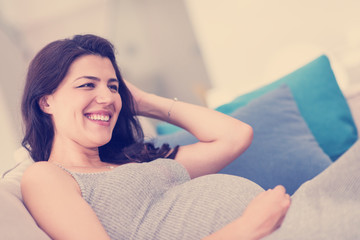 pregnant woman sitting on sofa at home