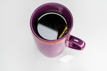 Filled cup of tea with tea bag from top