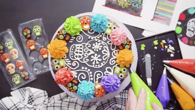 Step by step. Flat lay. Baker decorating multilayer chocolate cake with colorful italian buttercream frosting.