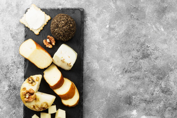 Snacks with wine - various types of cheeses, figs, nuts, honey, grapes on a gray background. Top view, copy space. Food background