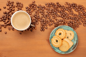 A photo of coffee in a vintage cup, with coffee beans and Danish butter cookies, with copy space