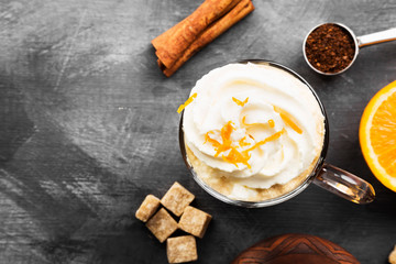 Autumn drink of coffee with orange juice and cream on dark background. Top view, copy space. Food background