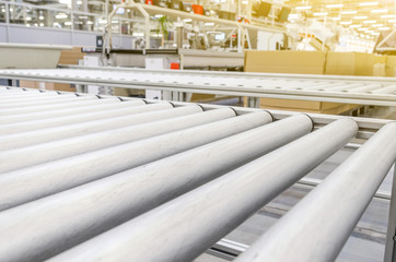 Table with metal rollers for transporting boxes in an industrial plant. Manufacturing enterprises