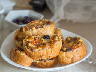 fried breakfast bread slices in the oven and egg, cheese, olives, tomato and sausage pieces