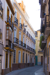 Building and street in Seville, Spain, details of old facade, wall with wooden frame windows.