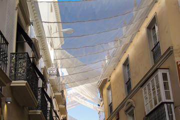 Obraz premium Shadow curtains on the street in Seville, Spain protecting tourists from sun and heat.