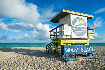 Traditional weathered wooden lifeguard tower in faded colors standing in setting sun on South Beach...