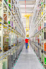 Large racks with coils of colored wires in an industrial plant. Wiring for cars - obrazy, fototapety, plakaty