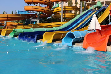 Fototapeta na wymiar Aquapark Waterpark slides on a beautiful sunny day with rushing water.