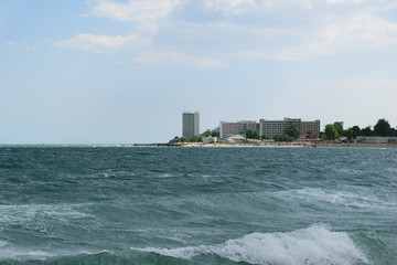 Neptun, Romania - July 8, 2017: The Black Sea changes colour to turquoise due to a natural but very rare phenomenon caused by microorganism. In the background is the beach resort in Neptun, Constanta © Florin