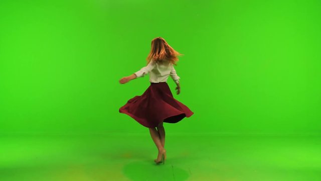 A beautiful dancer/actress poses for the camera, spins and smiles, trying out her dress. Over a green screen.